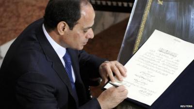 President Abdel Fattah al-Sisi signs a document of transferring authority