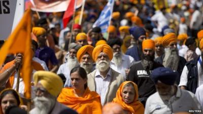 Sikhs, wearing orange, marching