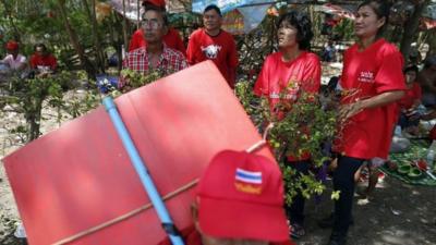 Pro-government "red shirt" supporters listen to their leader"s speech inside their encampment in the suburbs of Bangkok May 20, 2014