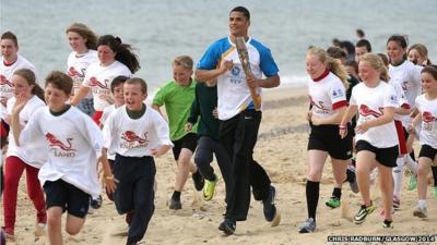 Anthony Ogogo runs with children on Lowestoft beach