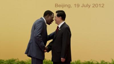 Former Chinese President Hu Jintao shakes hand with Benin's President Thomas Yayi Boni at the Great Hall of the People in Beijing on July 19, 2012.