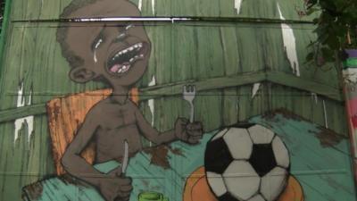 Street art in Brazil showing a boy with a football on his plate