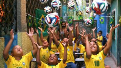 Children throwing footballs in the air