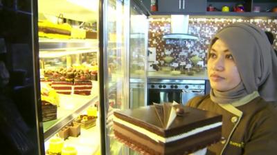 woman holding a chocolate cake