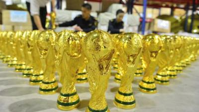 Warehouse floor covered in fake World Cup trophies