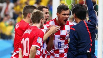 Croatia players argue with Referee Yuichi Nishimura