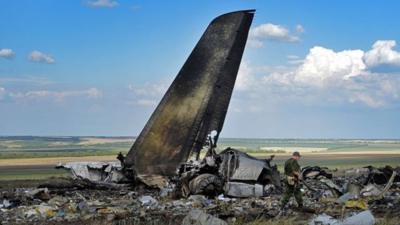 Pro-Russian militants look through the debris of Ukrainian plane site