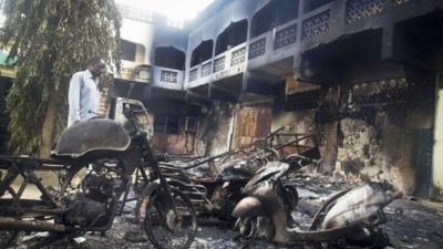 A man and destroyed vehicles and buildings