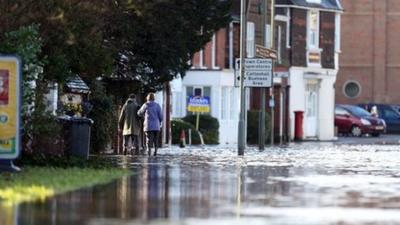 Couple walk down a flooded street in December 2013