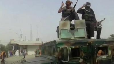 armed militants on top of vehicle