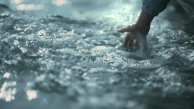 Child's hand in water from moving boat