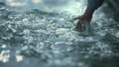 Child's hand in water from moving boat