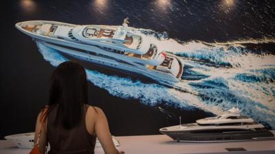 A woman looking at a Yacht model