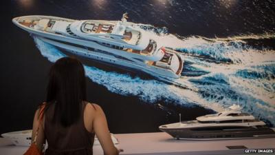 A woman looking at a yacht model