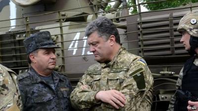 Ukrainian President Petro Poroshenko, wearing military fatigues, speaks with Ukrainian army's Anti-Terrorist Operation (ATO) officers at their headquarters