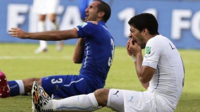 Giorgio Chiellini holds his shoulder after allegedly being bitten by Luis Suarez