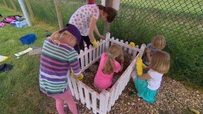 Children cleaning Dusty's gravestone