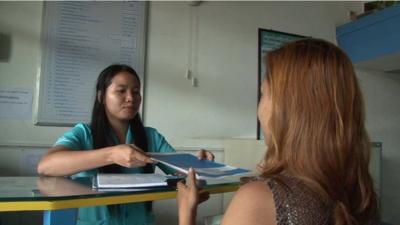 Nurse handing over leaflet to patient at counter