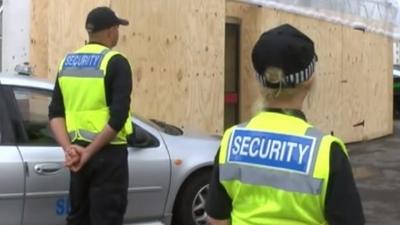 Security guards watch over the hidden Banksy artwork in Cheltenham