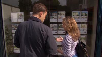 People looking in an estate agent window