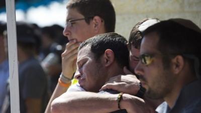 Friends and relatives mourn during a service for Gilad Shaar