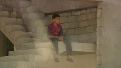 A child sits in a building site