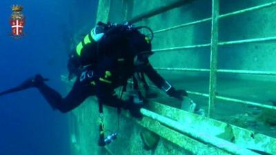 Italian police diver finds book on deck of Costa Concordia