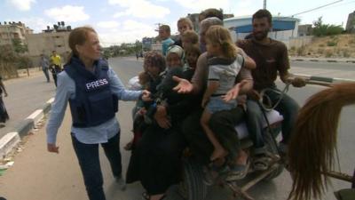 Yolande Knell speaking to people on cart