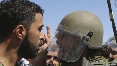 Palestinian protester and Israeli soldier