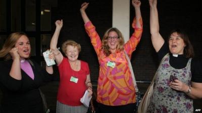 Female members of the clergy celebrate after members voted to approve the creation of female bishops at the Church of England General Synod in York,