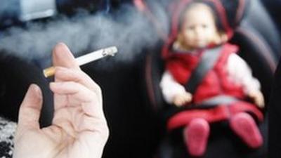 Smoking cigarette in a car with a small child in the back seat