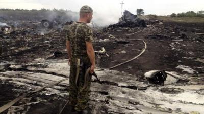 armed man at a site of a Malaysia Airlines Boeing 777 plane crash