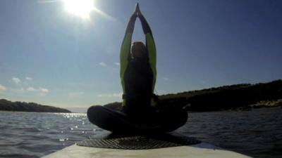 Woman in yoga position on a paddleboard