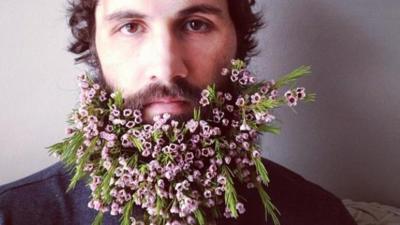 man with flowers in his beard