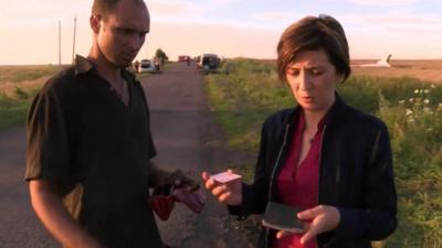 Man hands passenger belongings to Natalia Antelava