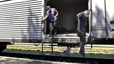 Dutch forensic experts jump from train holding bodies of MH17 crash