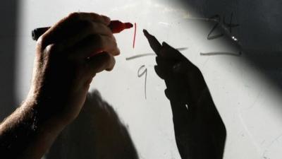 Teacher writing on whiteboard