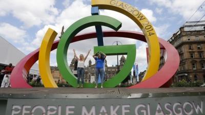 People posing on a Commonwealth Games sculpture