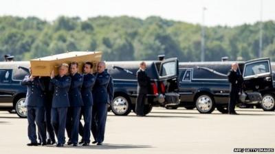 Dutch military personnel carry a coffin containing remains