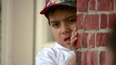 Young child looking around a corner