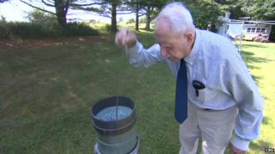 101-year-old volunteer weather observer, Richard G Hendrickson, measuring rainfall