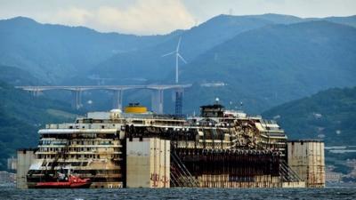 Refloated wreck of the Costa Concordia being dragged to the harbour near Genoa