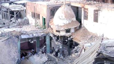 worshippers in ruins of mosque