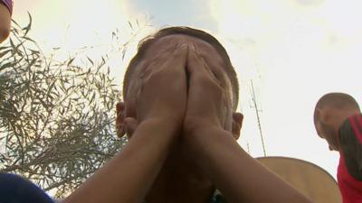 Man puts head in hands as Gaza children are buried