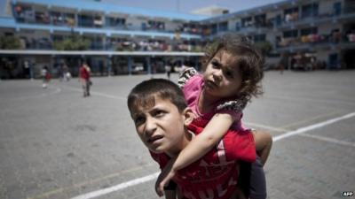 Displaced Palestinian children stand on the yard of an United Nations (UN) school in Jabalia in the northern Gaza Strip