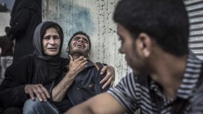 Palestinians mourn the death of a relative, who died when a UN school used as a shelter for internally displace people came under Israeli shelling in the Kamal Adwan hospital in Beit Lahia,