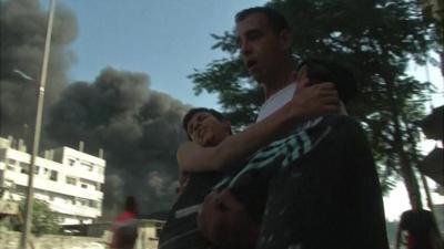 A man carries another man after Israeli strike