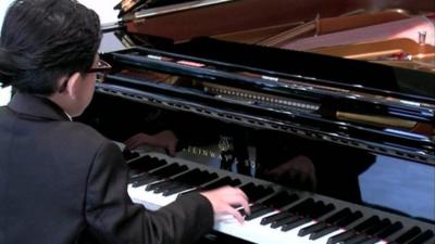 Boy playing a Steinway