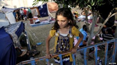 A Palestinian girl stands near makeshift tents in the garden of the Shifa hospital in Gaza City - 31 July 2014