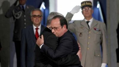 Frances President Francois Hollande (R) and German President Joachim Gauck (L) embrace as they pay their respects in the crypt of the National Monument of Hartmannswillerkopf in Wattwiller, eastern France